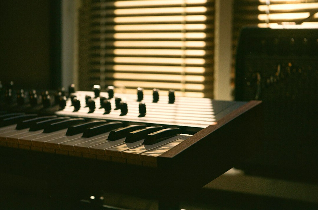 Vintage home recording studio desk with analog mixing console and warm lighting